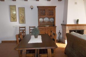uma sala de jantar com uma mesa e uma lareira em Casa Rural El Temple em Las Cuevas de Cañart