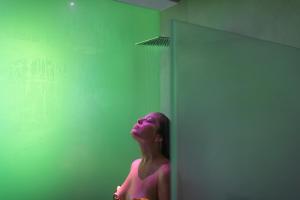 a woman standing in front of a green wall at Posia Retreat & Spa UNA Esperienze in San Foca