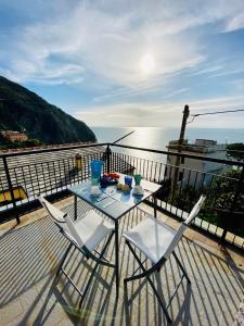 un tavolo e sedie su un balcone affacciato sull'acqua di Al castello a Riomaggiore
