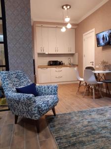 a living room with a chair and a kitchen at Old Tbilisi Apartments1 in Tbilisi City