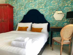 a bedroom with a bed with a chair and a desk at Villa Think Of Home in Khao Lak