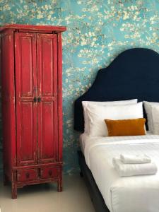 a bedroom with a red cabinet next to a bed at Villa Think Of Home in Khao Lak