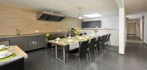 une cuisine avec une grande table et des chaises dans l'établissement Haus am Berg, à Bad Bertrich