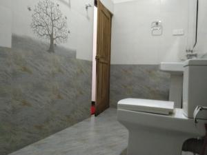 een badkamer met een toilet en een boom aan de muur bij sinhagiri hotel & restaurant in Tangalle +45 foto's