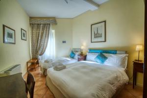 pokój hotelowy z 2 łóżkami i oknem w obiekcie Albergo Orologio w mieście Brescia