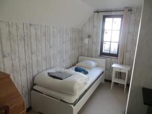 ein kleines Schlafzimmer mit einem Bett und einem Fenster in der Unterkunft Villa Eleonore in Koksijde