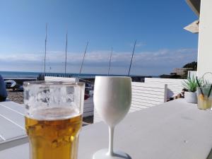 een glas bier op een tafel met uitzicht op de oceaan bij Nature Et Plage in Audembert