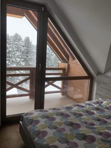 una camera con letto e porta scorrevole in vetro di Lukas Superior Apartment & SPA a Zlatibor