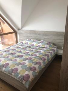 una camera da letto con un letto con un piumone colorato di Lukas Superior Apartment & SPA a Zlatibor