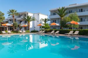 a pool at a hotel with chairs and umbrellas at Meliton Hotel in Theologos +25 photos