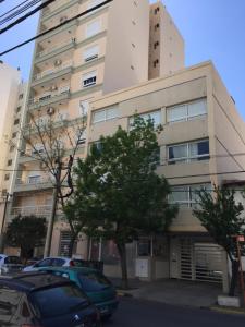 ein hohes Gebäude mit davor geparkt in der Unterkunft Dto Nuevo Barrio Universitario II , wifi y cochera-Check in express-Pet friendly in Bahía Blanca