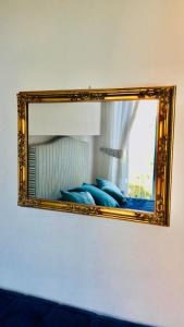uno specchio su una parete sopra un letto con cuscini blu di B&B Neapolis Bellini a Napoli