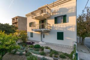 a building with a balcony and a garden at Courtyard seafront house in Kaštela