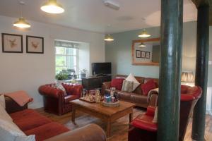 a living room with couches and a table at Comrie Croft in Crieff