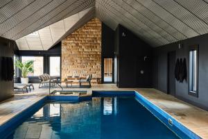 a swimming pool in a house with a brick wall at Lon Retreat in Point Lonsdale