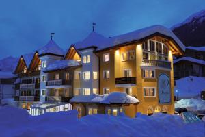 a large building with snow on the ground at Dolce Avita Hotel Spa & Resort in Andalo