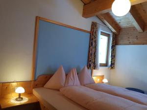 ein Bett in einem Zimmer mit einem großen Fenster in der Unterkunft Apart Foresta in Samnaun