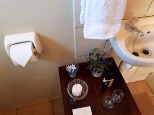 a bathroom with a table with a toilet and a sink at Die Buitekamer in Bredasdorp