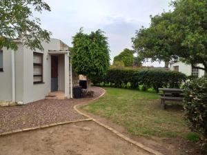 a yard with a bench and a building at Die Buitekamer in Bredasdorp