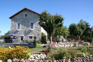 a stone house with a garden in front of it at Le Suc du Pommier in Yssingeaux