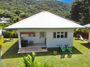 a small white house with two bikes parked in the yard at Fadine Self Catering in La Digue
