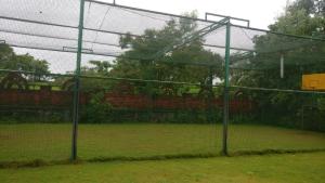 a tennis court with a net on a court at Rain Forest Resort in Lonavala