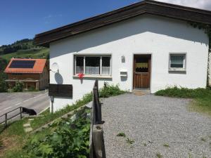 a white building with a brown door and a road at Berg & Skihütte -Schmittenhof in Laterns