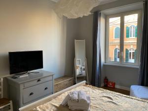um quarto com uma cama, uma televisão e uma cómoda em La Casetta del Flaminio em Roma