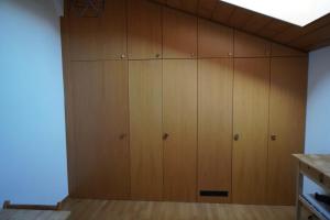 a large closet with wooden cabinets in a room at L'Echappée -B&B- in Sion