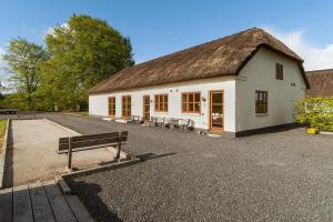 a white building with a bench in front of it at Schellerup Gård in Herning