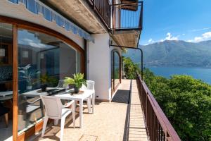 a balcony with a table and chairs and a view of the water at Villa Fantastica in Carate Urio