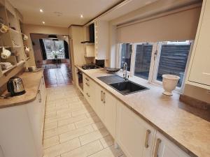 a large kitchen with a sink and a window at EasyRest Spalding - 6 Beds & Free Parking - Central & Quiet Location - Entire Spacious House in Spalding
