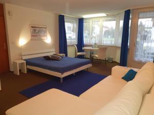 ein Schlafzimmer mit einem Bett, einem Sofa und einem Tisch in der Unterkunft BnB im Grossacker in Münchwilen