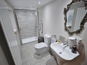a bathroom with a toilet and a sink and a shower at EasyRest Spalding - 5 Beds & Free Parking - Central & Quiet Location - 3rd Bedroom Optional - Entire Spacious House in Spalding