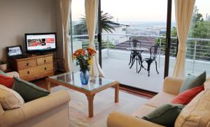 una sala de estar con un jarrón de flores sobre una mesa en Harbour View Guest Suite en Ciudad del Cabo