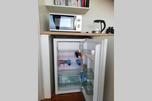 a refrigerator with its door open next to a microwave at Harbour View Guest Suite in Cape Town