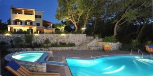 a house with a swimming pool in front of a house at Villa Melenia in Almiros Beach