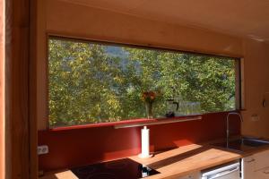 een keuken met een groot raam boven een aanrecht bij Tiny Häuschen in Ossiach +18 foto's