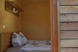 een klein bed in een kamer met een houten muur bij Tiny Häuschen in Ossiach