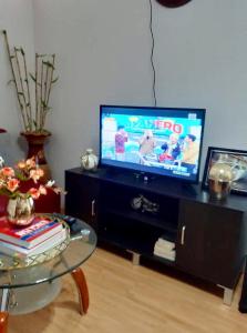 a living room with a tv and a glass table at Estien’s cozy condo to stay with kitchen in Manila