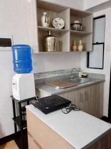 a kitchen with a counter with a microwave and a sink at Estien’s cozy condo to stay with kitchen in Manila