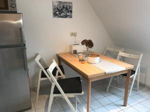 a kitchen with a wooden table with chairs and a refrigerator at Hendreich's Hof in Boitin Resdorf