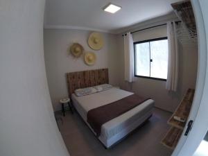 a small bedroom with a bed and a window at ImobIlha - Casa de Praia Ingleses - Santinho in Florianópolis