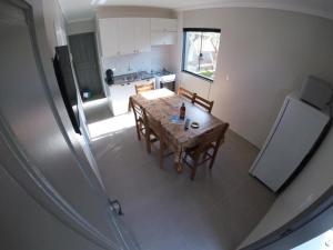 a kitchen with a table and chairs and a kitchen with a table and a refrigerator at ImobIlha - Casa de Praia Ingleses - Santinho in Florianópolis