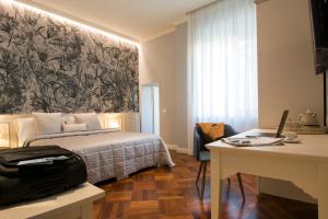 a bedroom with a bed and a desk with a laptop at B&B PISTOIA INN in Pistoia