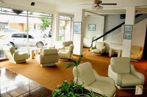 ein Wohnzimmer mit ein paar Stühlen und einem Tisch in der Unterkunft Hotel Frasi's in San Clemente del Tuyú