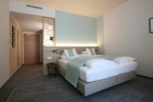ein Schlafzimmer mit einem großen Bett mit weißen Kissen in der Unterkunft Donau Lodge in Ybbs an der Donau