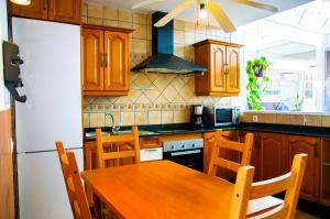 a kitchen with a wooden table and a white refrigerator at Casa Tigot in Puerto del Carmen