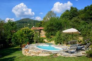 una piscina con 2 sillas y una sombrilla en Casetta nel Bosco Naturas con piscina privata e gratuita en Rossana
