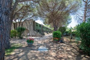 a building with some plants and flowers in a yard at Condominio Dunelba in Marina di Campo